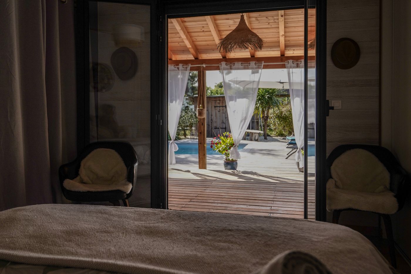 Chambre ouverte sur la pergola et la piscine par une baie vitrée